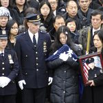 Liu's widow Pei Xia Chen, holding the police flag from his casket<br/>
